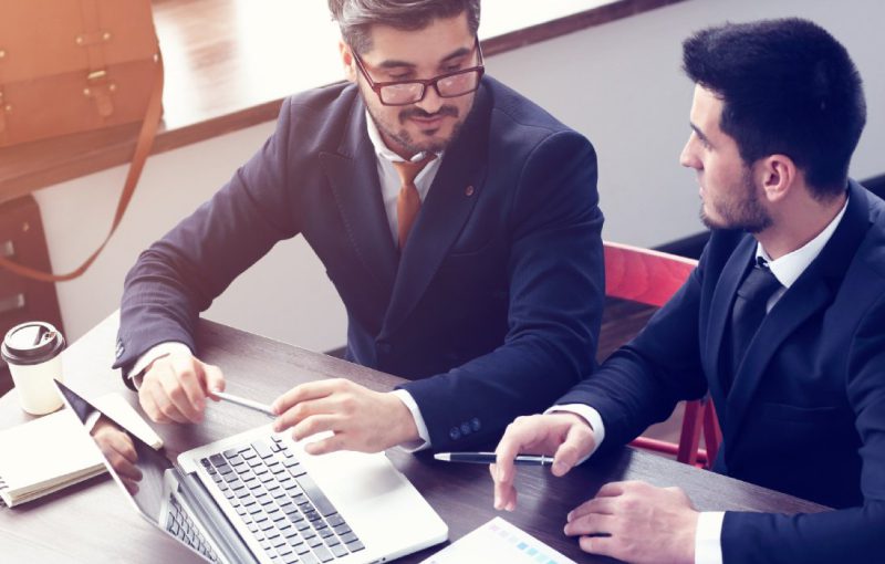 two-young-businessmen-working-laptop-modern-office-beard-hipster-businessmen-film-effect-lens-flare-800x510